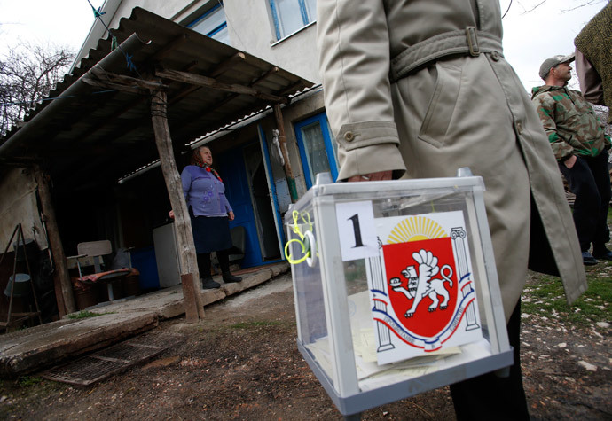 An election official carries a mobile ballot box after a house visit during voting in a referendum in Dobroye outside Simferopol March 16, 2014.(Reuters / David Mdzinarishvili)
