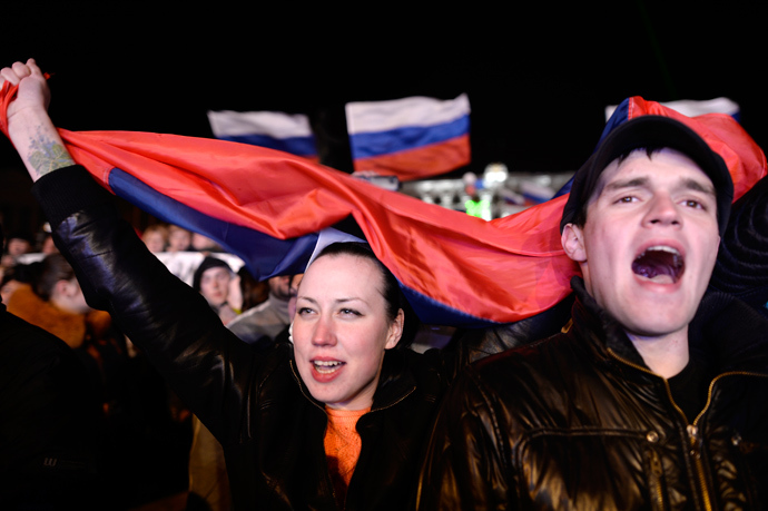 People sing the Russian national anthem as they celebrate in Simferopol's Lenin Square on March 16, 2014 after exit polls showed that about 95.5 percent of voters in Ukraine's Crimea region supported union with Russia (AFP Photo / Dimitar Dilkoff)