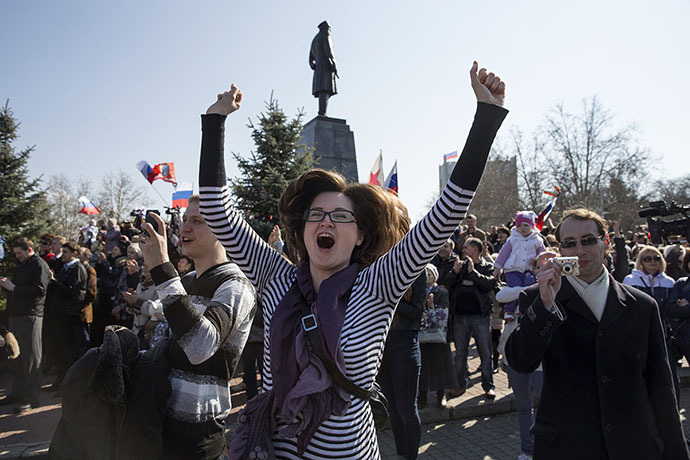 A woman jumps for joy during a broadcast of Russian President Vladimir Putin's address to the Federal Assembly in Sevastopol March 18, 2014. (Reuters / Baz Ratner)