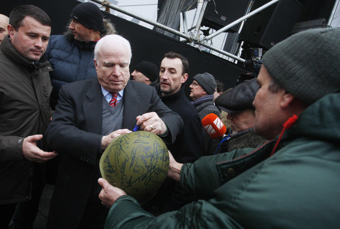 US Senator John McCain (2nd L) signs a military helmet for a protester at Independence Square in Kiev on December 15, 2013. (AFP Photo / Yuriy Kirmichny) 