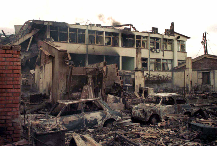 Smoke rises over the local red cross office destroyed in last night's NATO air strike on centre of Kosovo's capital Pristina March 29, 1999 (Reuters)