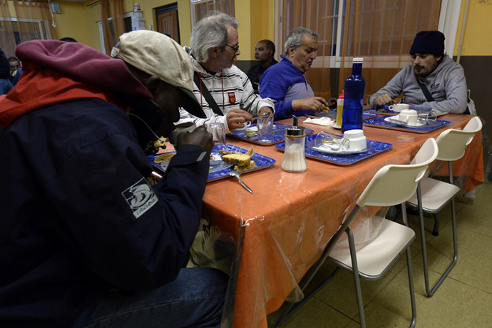 People have breakfasts at a soup kitchen in Barcelona (AFP Photo / Lluis Gene)