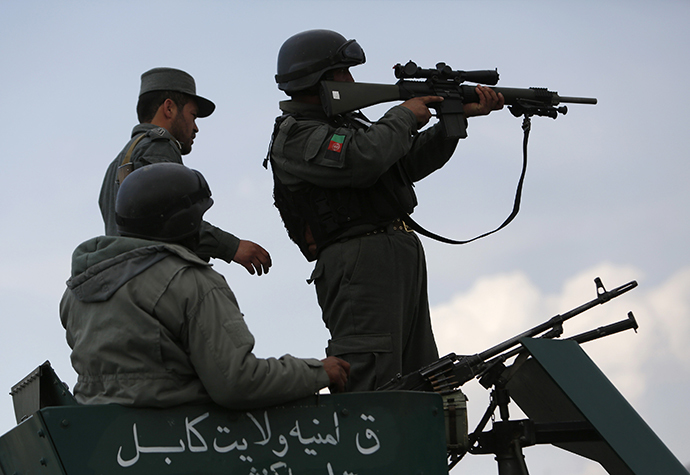 Afghan policemen take their positions atop a military vehicle near an election commission office during an attack by gunmen in Kabul March 29, 2014. (Reuters / Mohammad Ismail)