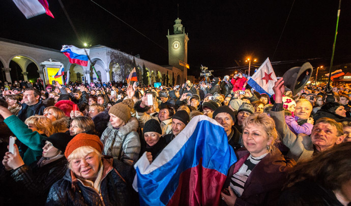 People celebrate the transition to Moscow time near a city clock tower at a railway station in Simferopol on March 30, 2014. (AFP Photo/Dmitry Serebryakov)