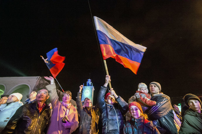 People celebrate the transition to Moscow time near a city clock tower at a railway station in Simferopol on March 30, 2014. (AFP Photo/Dmitry Serebryakov)