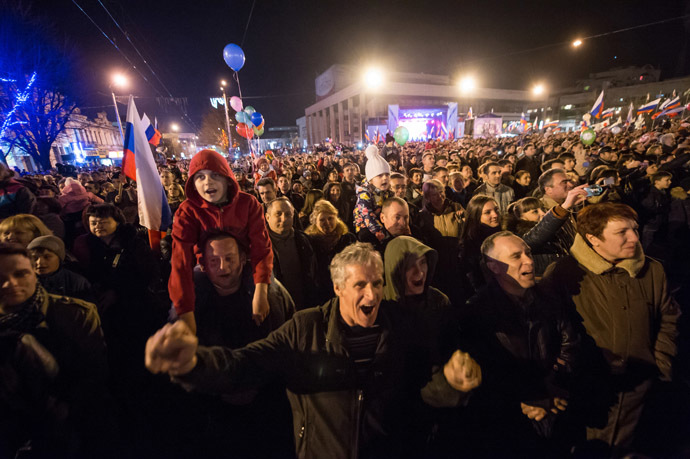 People wave Russian flags and cheer in the center of the Crimean city of Simferopol on March 21, 2014. (AFP Photo/Dmitry Serebryakov)