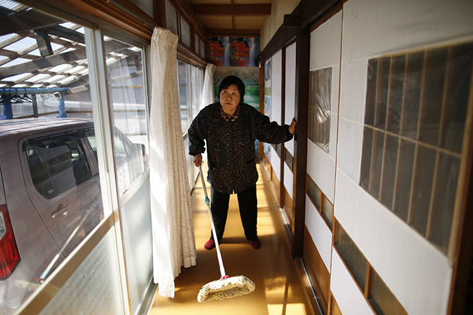 Kimiko Koyama, 69, who evacuated from the Miyakoji area of Tamura three years ago, dusts off her house after she returned to her home with her husband Toshio, 76, in Tamura, Fukushima prefecture April 1, 2014. (Reuters / Issei Kato)