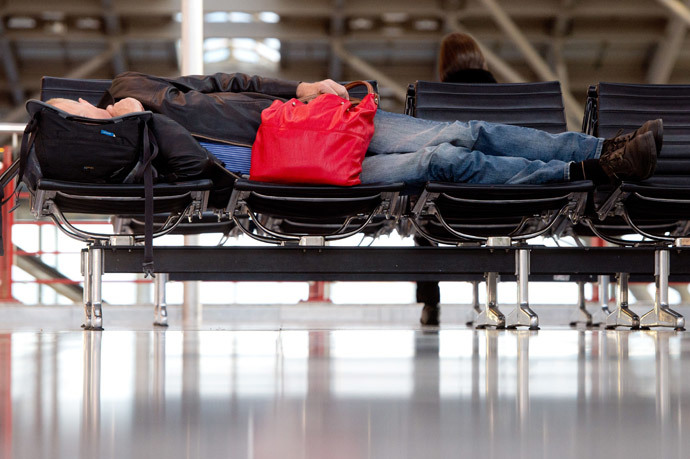 A man sleeps at the airport in Stuttgart, southern Germany, on April 2, 2014. (AFP Photo / DPA / Sebastian Kahnert / Germany out) 