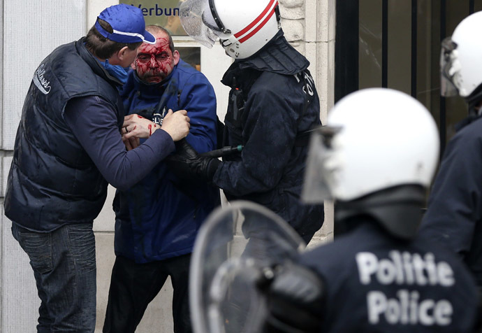 An injured demonstrator is helped by riot police officers after being hit by a stone thrown by other demonstrators during a European trade unions protest against austerity measures, in central Brussels April 4, 2014. (Reuters/Francois Lenoir)