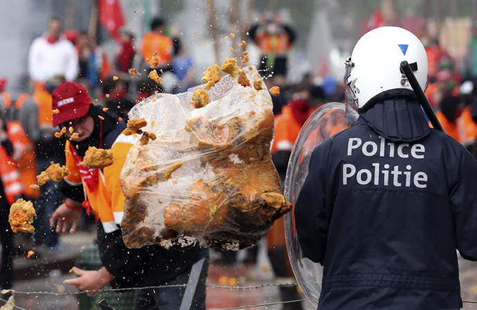 A demonstrator throws garbage towards riot police officers during a European trade unions protest against austerity measures, in central Brussels April 4, 2014. (Reuters/Francois Lenoir)