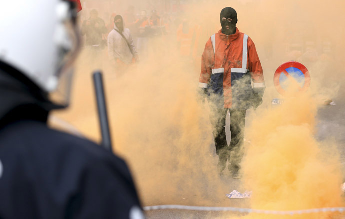 A demonstrator stands in front of riot police officers during a European trade union protest against austerity measures, in central Brussels April 4, 2014. (Reuters/Francois Lenoir)