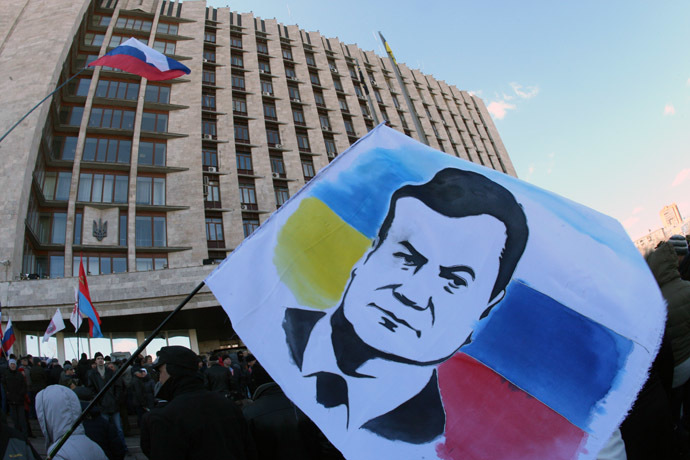 A demonstrator holds a flag with the portrait of deposed Ukrainian President Viktor Yanukovych during a rally of pro-Russia supporters outside the regional government administration building in the center of the eastern Ukrainian city of Donetsk during on April 5, 2014. (AFP Photo)