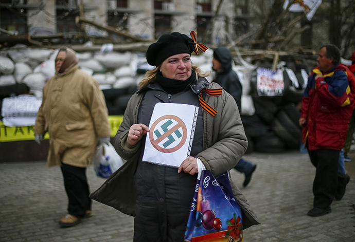 A pro-Russia protester holds an anti-swastika sign in front of a barricade outside a regional government building in Donetsk, in eastern Ukraine April 11, 2014. (Reuters / Gleb Garanich)