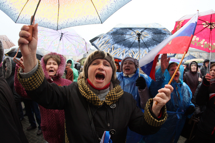 Pro-Russian activists hold umbrellas under the rain and shout slogans during a rally near a barricade outside the regional government building in the eastern Ukrainian city of Donetsk on April 13, 2014 (AFP Photo / Alexander Khudoteply)
