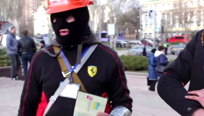 A protester in Donetsk shows his Ukrainian passport. Still from RT video