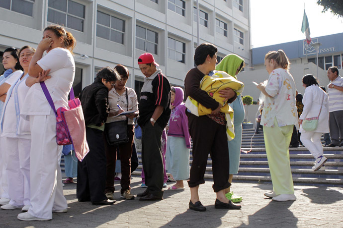 People stand along a street after evacuating a hospital following an earthquake in Puebla April 18, 2014. (Reuters/Imelda Medina)