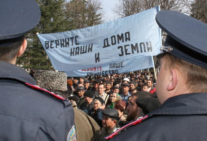 An unsanctioned Crimean Tatar demonstration demanding the land issue settled. The streamer says in Russian: "Give back our homes and land! Restore our property!", March 20, 2008 (RIA Novosti/Server Amzaev)