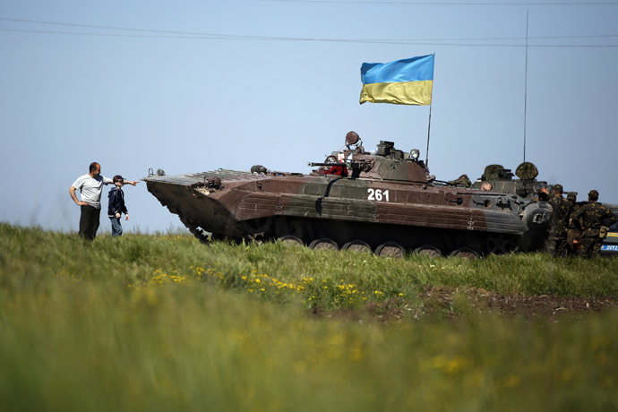 A man and boy stand in front of a Ukrainian armoured personnel carrier at a checkpoint in Mariupol, eastern Ukraine May 7, 2014. (Reuters/Marko Djuric)