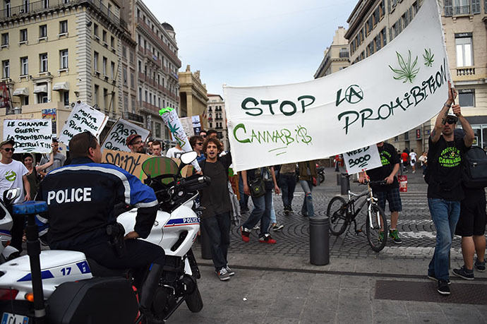 People hold a banner reading "Stop the prohibition" as they face policemen during a protest to call for the legalization of marijuana on May 10, 2014, at the Old Harbour in Marseille, southern France. (AFP Photo / Anne-Christine Poujoulat)