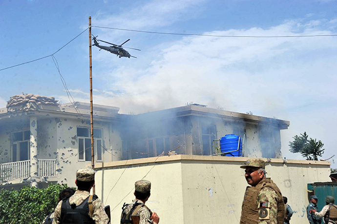 A NATO helicopter hovers as smoke rises from the site of a suicide attack in Jalalabad province on May 12, 2014 (AFP Photo / Noorullah Shirzada)