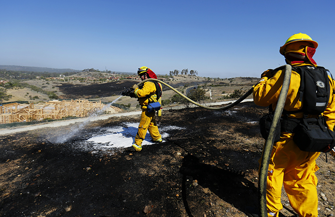 Fire-fighters work to put out spot fires caused by strong winds as they keep close watch over the Bernardo fire north of San Diego, California May 14, 2014. (Reuters / Sandy Huffaker)