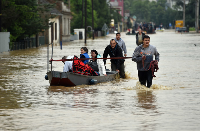 People walk through a flooded street in Obrenovac, 40 kilometers west of Belgrade, on May 16, 2014. (AFP Photo/Andrej Isakovic)