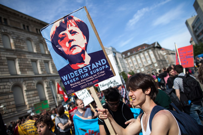 A protester holds a banner featuring German chancellor Angela Merkel reading 'resistance against her Europe' during a Blockupy movement protest on May 17, 2014 in Berlin. (AFP Photo/DPA/Maja Hitji)
