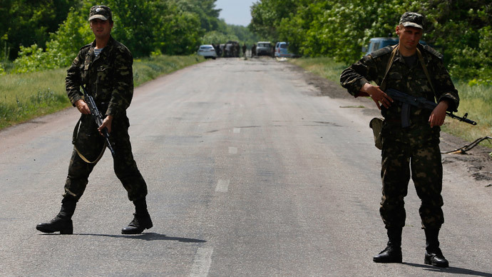 Ukrainian soldiers block traffic near the site (seen in background) where Ukrainian servicemen were killed on the outskirts of the eastern Ukrainian town of Volnovakha, south of Donetsk May 22, 2014.(Reuters / Yannis Behrakis )