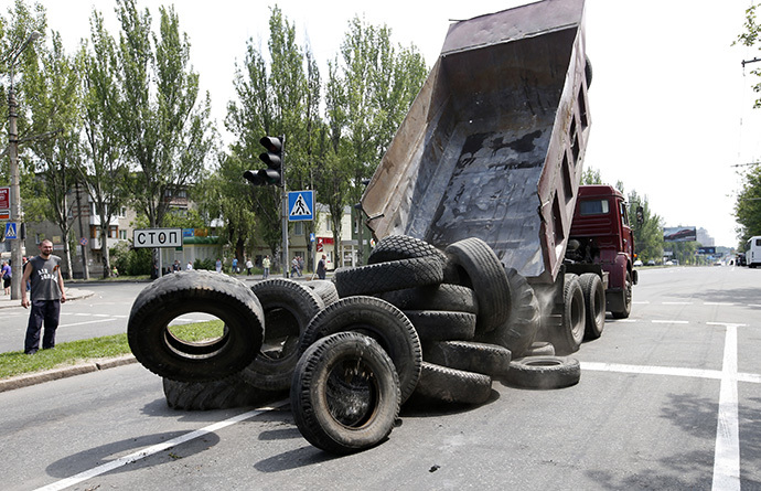 A truck unloads tyres as supporters of the self-proclaimed Donetsk People's Republic erect a barricade on a road which leads to an airport in the eastern Ukrainian city of Donetsk, May 28, 2014. (Reuters / Maxim Zmeyev)