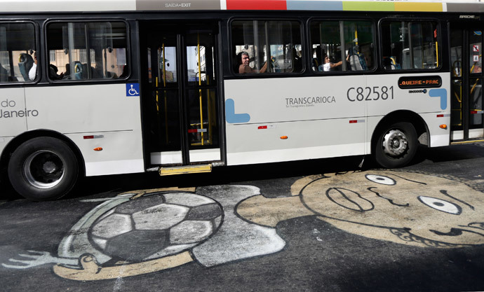 A public bus drives over a graffiti referencing the 2014 World Cup in Rio de Janeiro May 22, 2014. (Reuters / Ricardo Moraes)