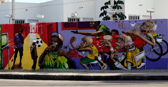 A man walks past by graffiti painted on the a wall in reference to the 2014 World Cup in Rio de Janeiro May 14, 2014. (Reuters / Sergio Moraes)