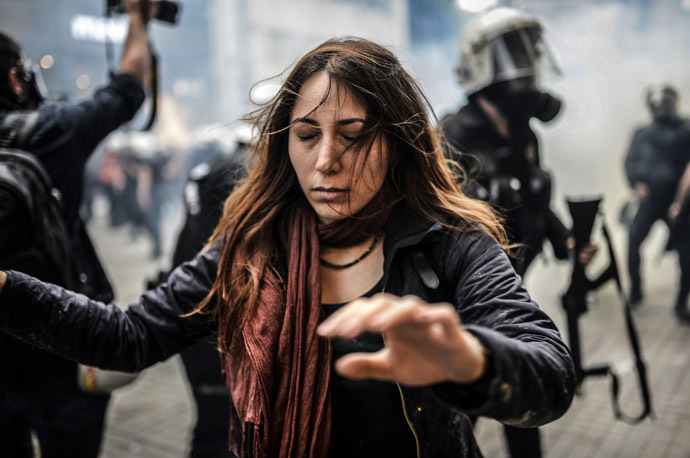 A protester walks away with closed eyes as Turkish riot police officers fire tear gas to disperse demonstrators gathered on the central Istoklal avenue near Taksim square in Istanbul, on May 31, 2014, as the police blocked access to the square during the one year anniversary of the Gezi park and Taksim square demonstrations. (AFP Photo/Bulent Kilic)