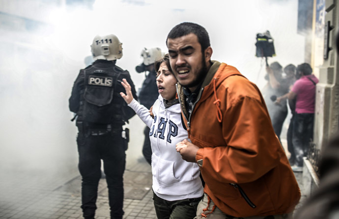 Protesters run away as Turkish riot police officers fire tear gas to disperse demonstrators gathered on the central Istoklal avenue near Taksim square in Istanbul, on May 31, 2014, as the police blocked access to the square during the one year anniversary of the Gezi park and Taksim square demonstrations. (AFP Photo/Bulent Kilic)