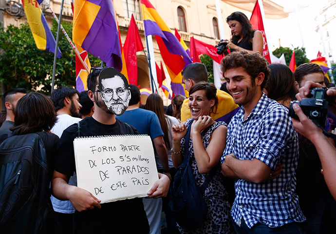 A man wearing a mask depicting Spanish Prime Minister Mariano Rajoy holds a placard which reads, "I am part of the 5.5 million unemployed in this country" during a protest against the Spanish monarchy in the Andalusian capital of Seville, southern Spain June 2, 2014. (Reuters / Marcelo del Pozo)