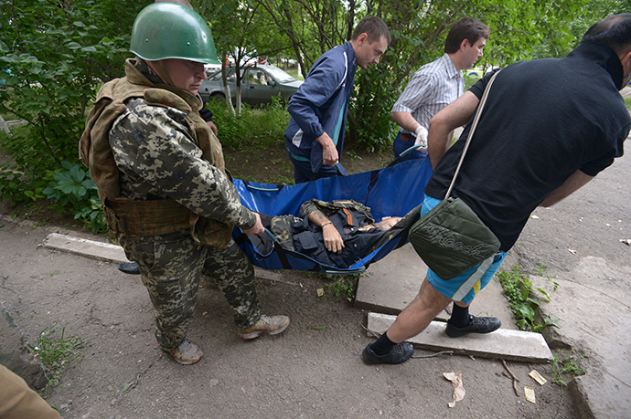 A fighter of the people's militia and local residents evacuate a militiaman wounded during a battle with Ukraine's border guards in the Mirny neighborhood on the outskirts of Lugansk (RIA Novosti / Evgeny Biyatov)