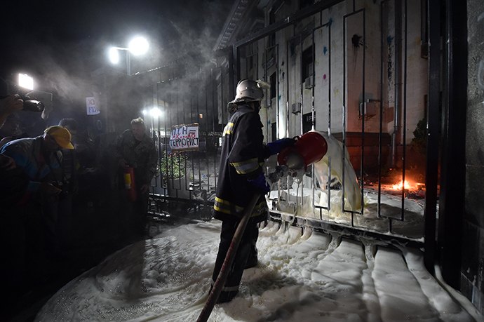 A fireman extinguishes the flames from a Molotov coctail thrown by a protester during rally against the Russian President Vladimir Putin in front of the Russian Embassy in Kiev on June 14, 2014 (AFP Photo / Sergey Supinsky)
