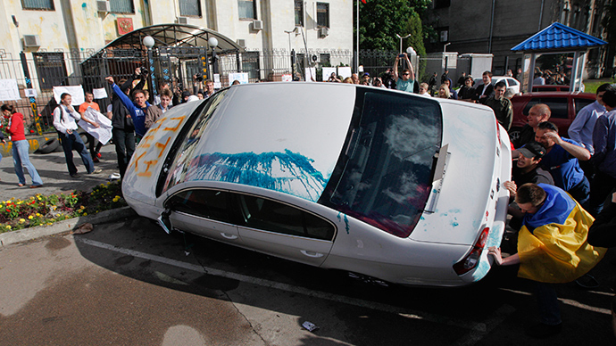 Pro-Ukrainian people overturn a car during a rally in front of the Russian embassy in Kiev June 14, 2014 (Reuters / Valentyn Ogirenko)