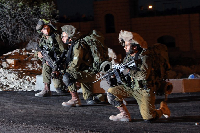 Israeli soldiers patrol an area in the West Bank town of Hebron on June 15, 2014, as they search for three teenagers who went missing near a West Bank settlement. (AFP Photo / Hazem Bader)