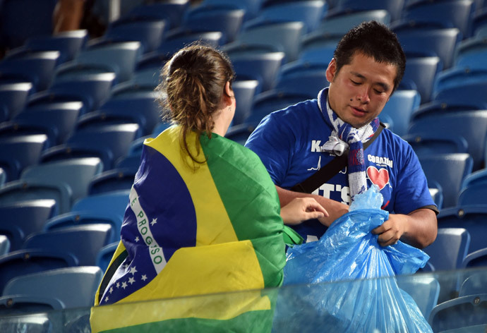 A Japanese fan cleans the tribune after a Group C football match between Japan and Greece at the Dunas Arena in Natal during the 2014 FIFA World Cup on June 19, 2014. (AFP Photo / Toshifumi Kitamura) 