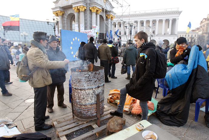 Pro-EU supporters huddle over a fire after spending the morning of November 28 at the protest camp in Independence Square in Kiev (Reuters / Vasily Fedosenko)