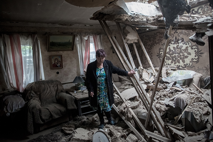 A woman stands in her home destroyed in the Ukrainian troops' shelling of the Golubovka village near Slavyansk on June 27, 2014. (RIA Novosti / Andrey Stenin)