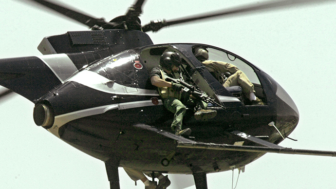 ARCHIVE PHOTO: Members of the US Blackwater private security company fly a Hughes 500 helicopter over the Tigris river in Baghdad, during a patrol 05 May 2004 (AFP Photo / Marwan Namaani)