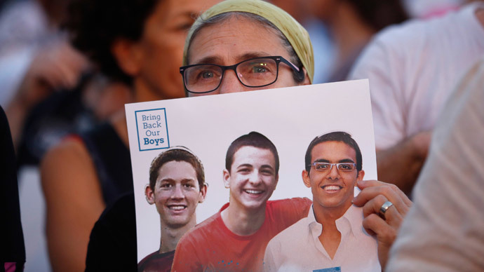 An Israeli woman holds a sign with images of three missing Israeli teenagers, at a rally in Rabin Square in the coastal city of Tel Aviv.(Reuters / Baz Ratner)