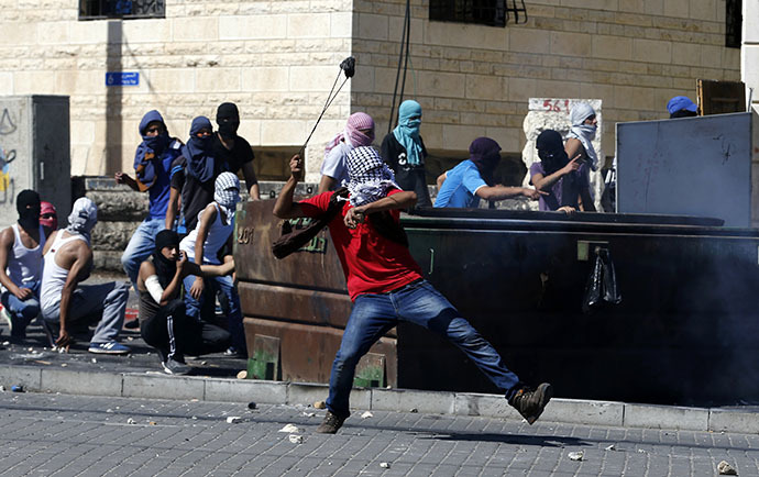 A Palestinian uses a sling to hurl a stone towards Israeli police during clashes in Shuafat, an Arab suburb of Jerusalem July 2, 2014. (Reuters / Baz Ratner)