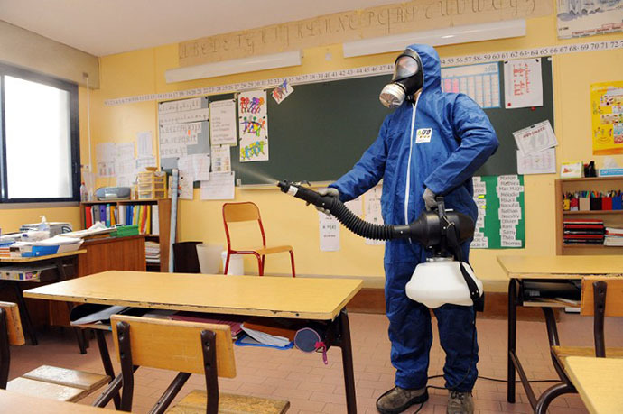A man sprays a disinfectant against the swine flu virus on November 18, 2009 in a classroom of the Georges Brassens school in Baillargues, southern France. (AFP Photo / Pascal Guyot)