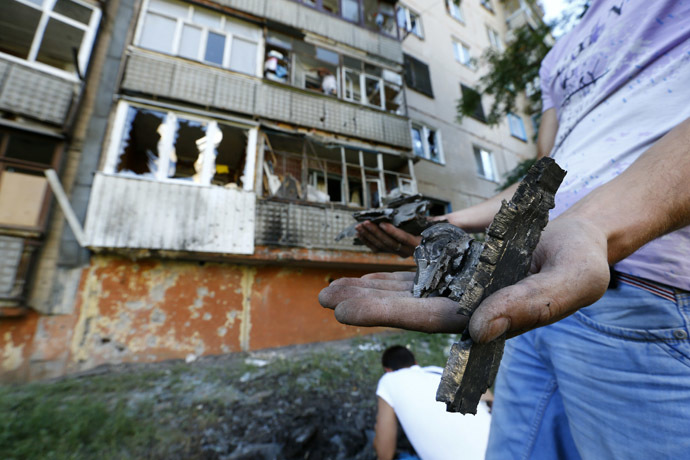 A local resident holds fragments of shrapnel near an apartment damaged by shelling in Slaviansk in eastern Ukraine June 29, 2014. (Reuters/Shamil Zhumatov)