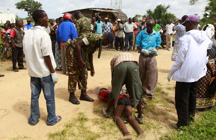 Policemen recover the slain body of a man killed when gunmen attacked Hindi village, near Kenya's coastal town of Lamu, July 6, 2014. (Reuters/Joseph Okanga)