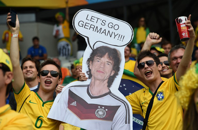Brazilian fans hold a cardboard cutout of The Rolling Stones' Mick Jagger before the semi-final football match between Brazil and Germany at The Mineirao Stadium in Belo Horizonte during the 2014 FIFA World Cup on July 8, 2014. (AFP Photo / Vanderlei Almeida)