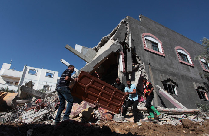 Palestinians carry a door from a destroyed house following what police said was an Israeli air strike in central Gaza Strip July 9, 2014.(Reuters / Ashraf Amrah)