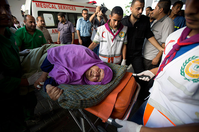 A Palestinian woman is brought into an hospital on a stretcher after she was injured in an Israeli air strike on July 11, 2014 in Gaza City. (AFP Photo / Mohammed Abed)